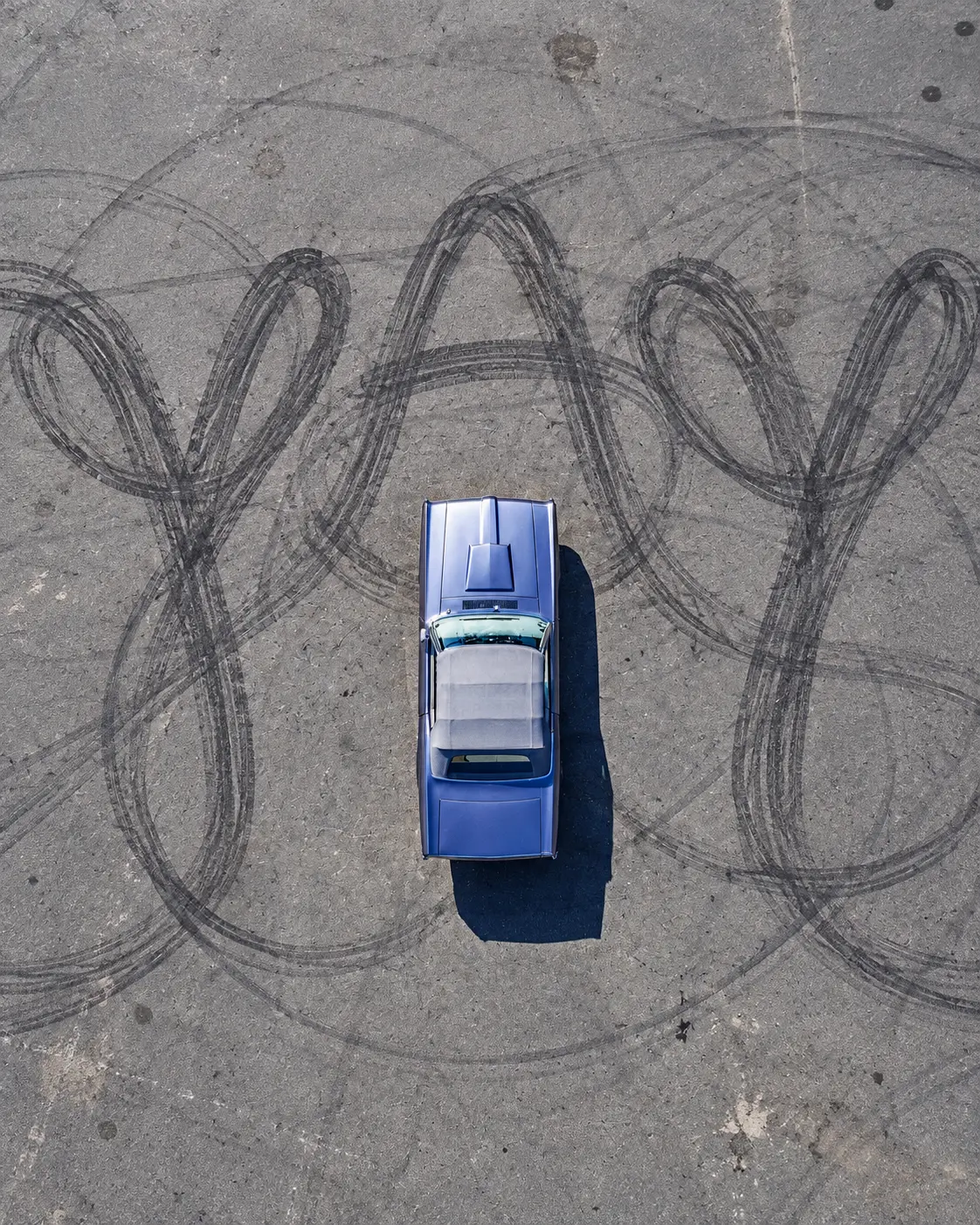 Aerial view of a classic car inside tire marks spelling YAY